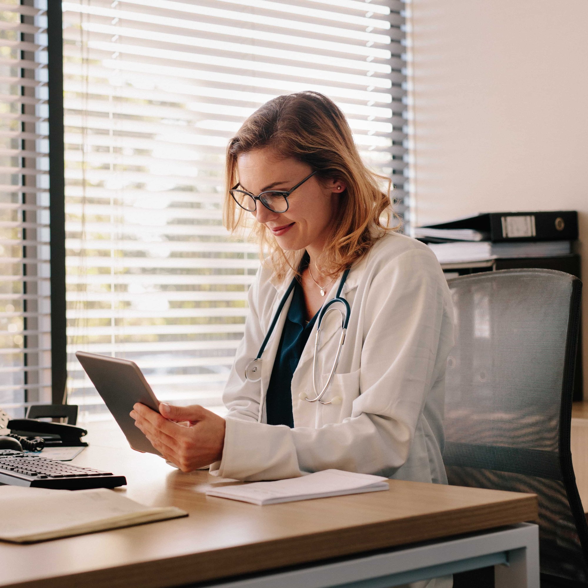 Female doctor working on her tablet pc_251687976-min-1